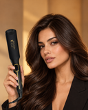 A woman with long wavy brown hair holds an iRossi 2.0 infrared heat styling tool.